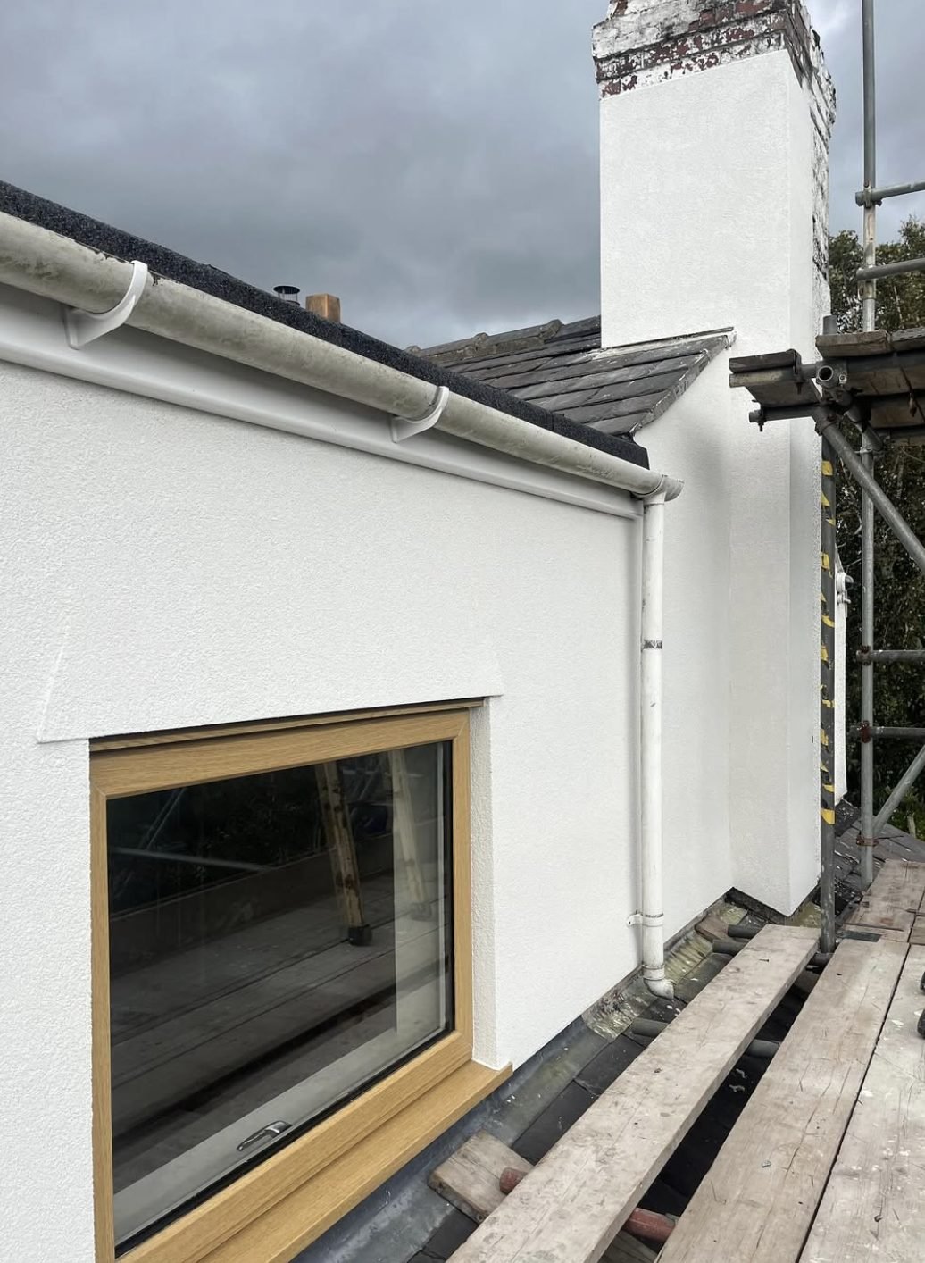 Chimney stack and dormer cheek rendered white, photographed from the scaffold