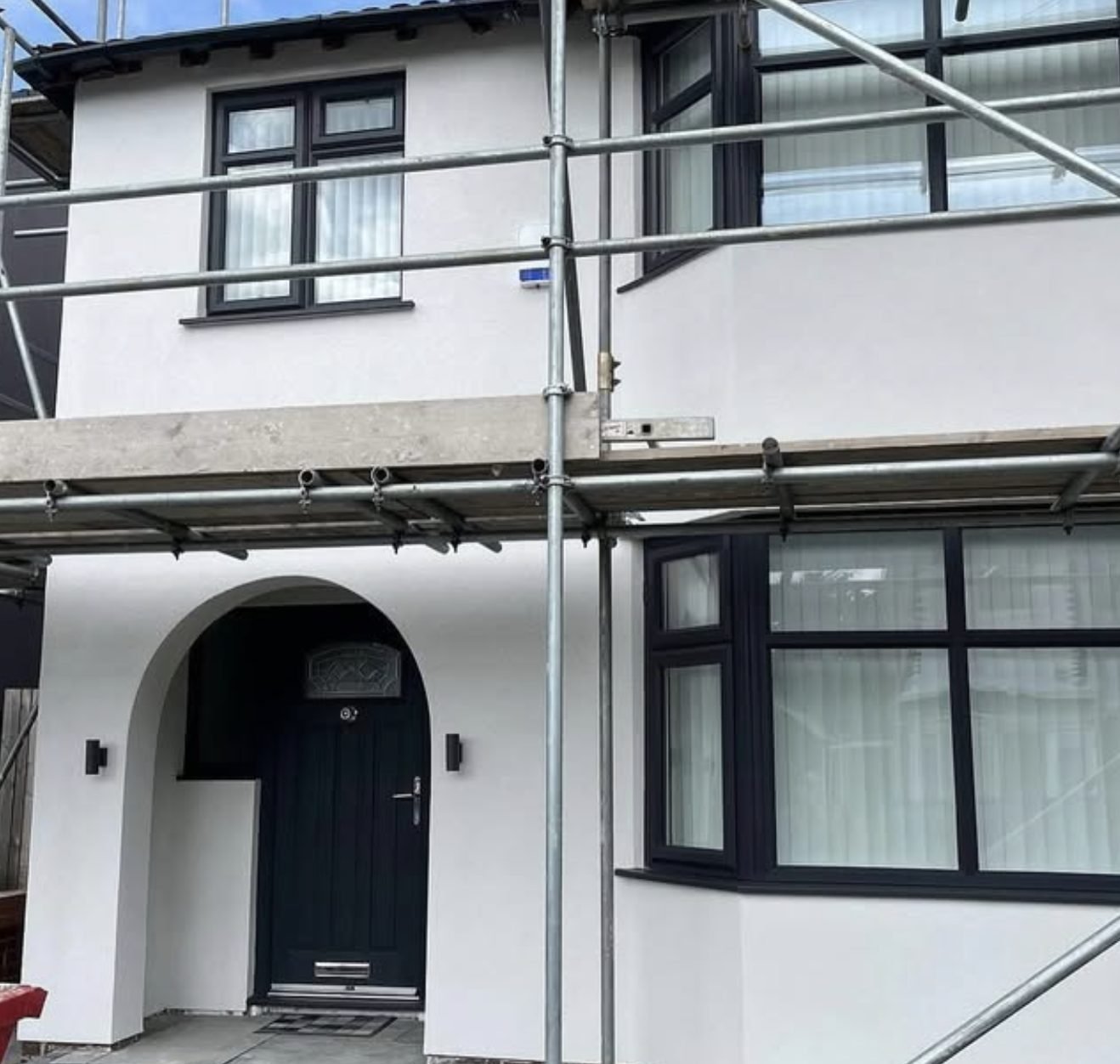 Semi-detached house in fresh white render with scaffold still standing